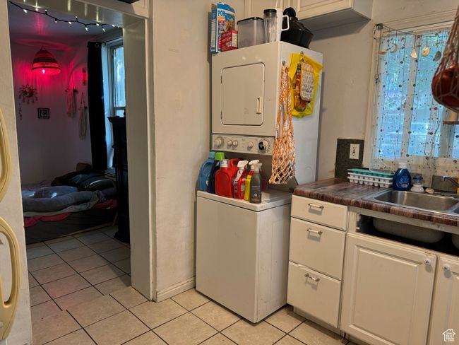 Laundry room featuring stacked washer and dryer, laundry area, and light tile patterned flooring | Image 11