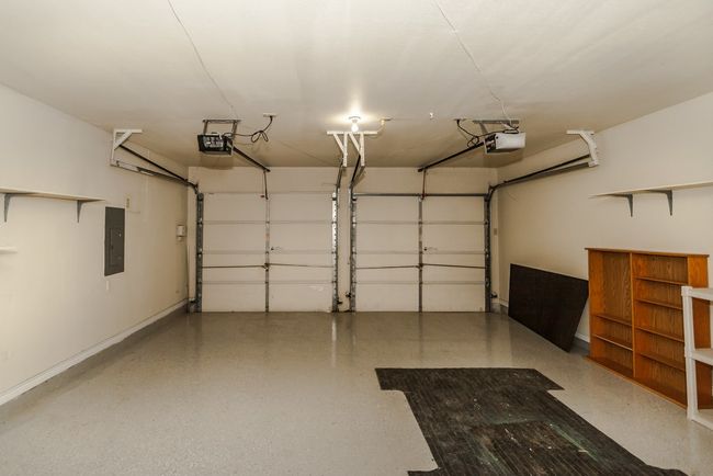 Garage featuring a garage door opener and electric panel | Image 23
