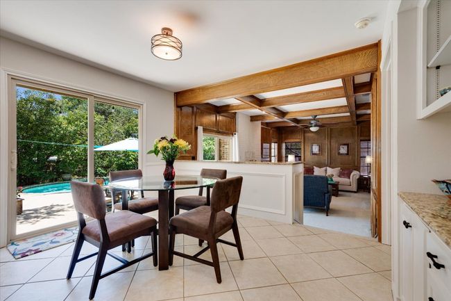 Dining space featuring light tile patterned floors, cabinets and shelves, with plenty of natural light | Image 15