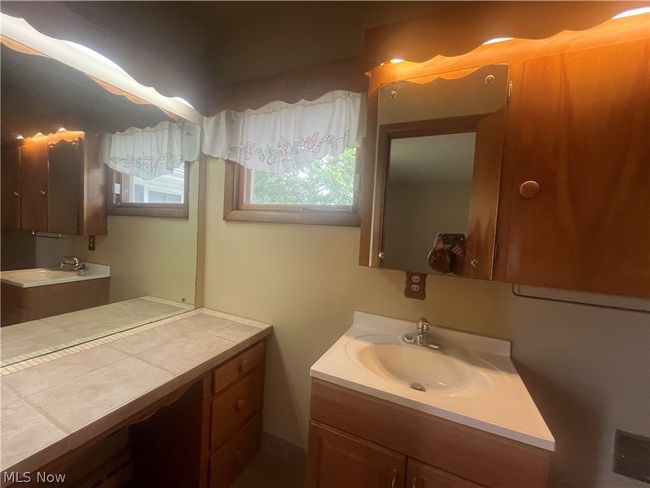 Bathroom featuring vanity with extensive cabinet space | Image 12