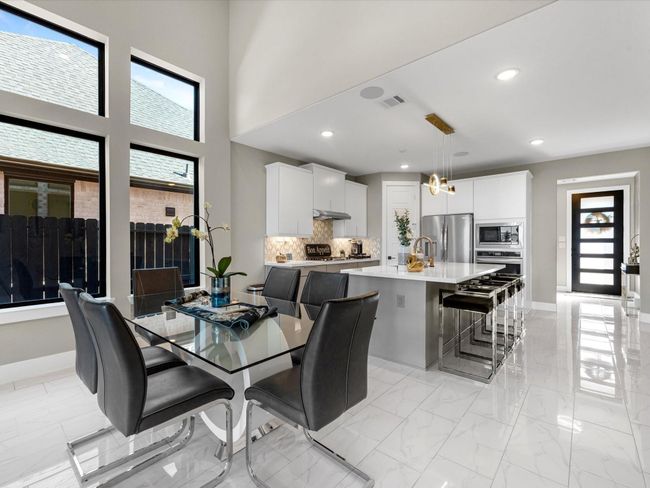 Sleek and modern this space is highlighted by a large window providing natural light and airy feel, boasting high end appliances, beautiful 2 tones cabinets and stylish backsplash, the island provide extra seating which adds functionality to the space, with luxury finishes and tones of upgrades this house is easy to maintain. | Image 18