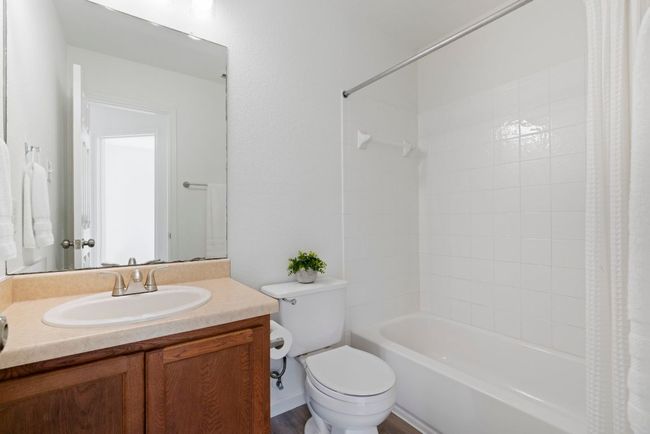 • This full bathroom combines simplicity and functionality in a compact design. Equipped with all the essentials, it features a bathtub and shower combo, a toilet, and a sink with vanity. | Image 21