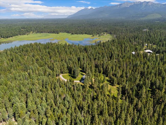 Aerial view of property and surrounding area featuring a forest and a water and mountain view | Image 51