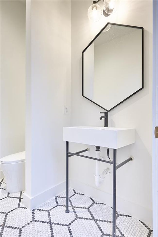 The conveniently located pool bathroom offers easy outdoor access and featuring a Hive pattern matte porcelain mosaic tile floor. | Image 47