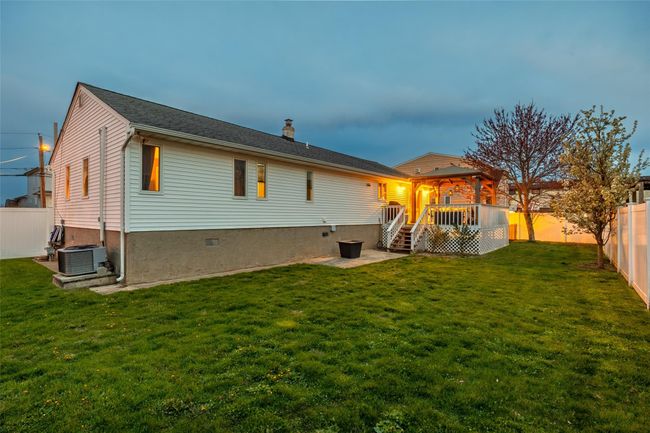 Rear view of property with a lawn, a fenced backyard, a chimney, and a deck | Image 5