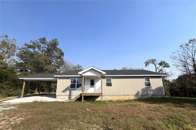 View of front facade with a carport and a front lawn | Image 1