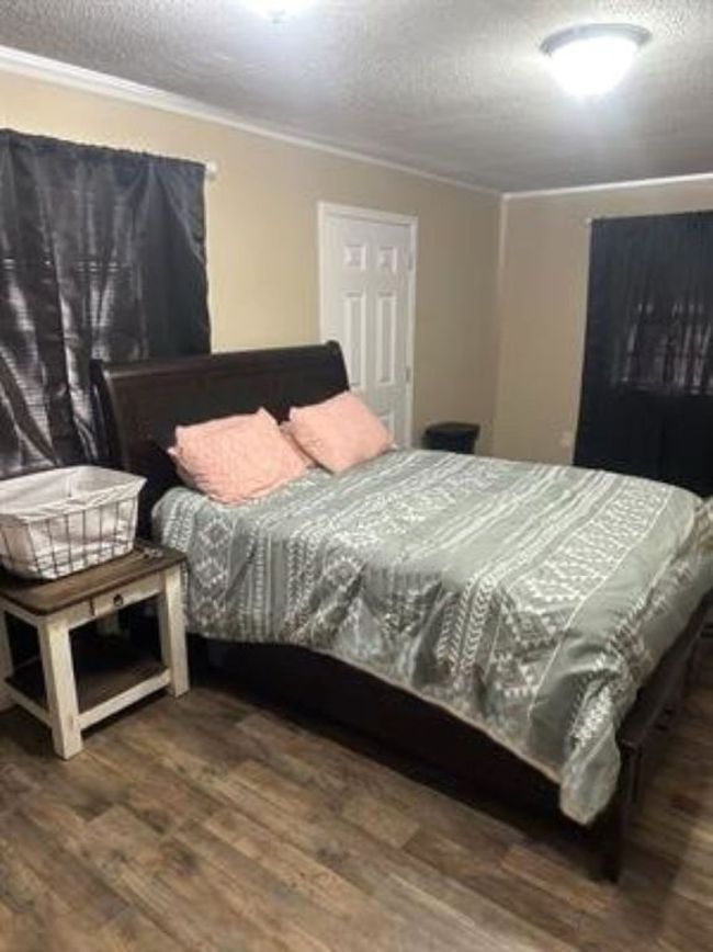 Bedroom featuring a textured ceiling, wood finished floors, and ornamental molding | Image 10