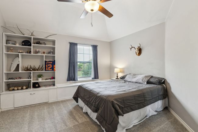 Carpeted bedroom featuring ceiling fan and lofted ceiling | Image 25