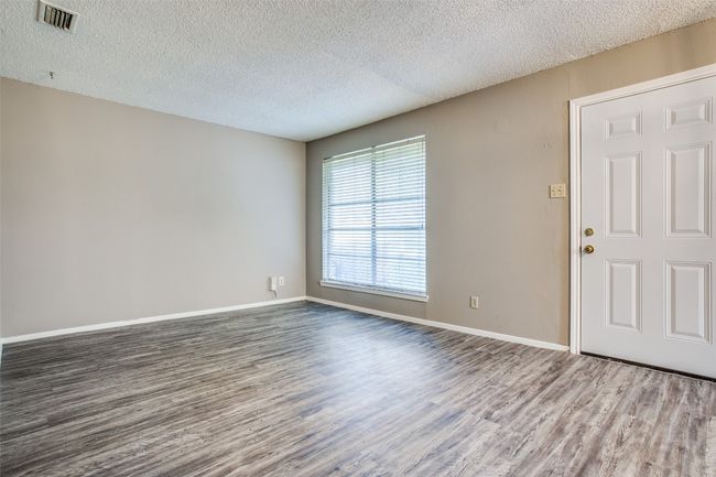 Spare room with visible vents, a textured ceiling, dark wood-style flooring, and baseboards | Image 7