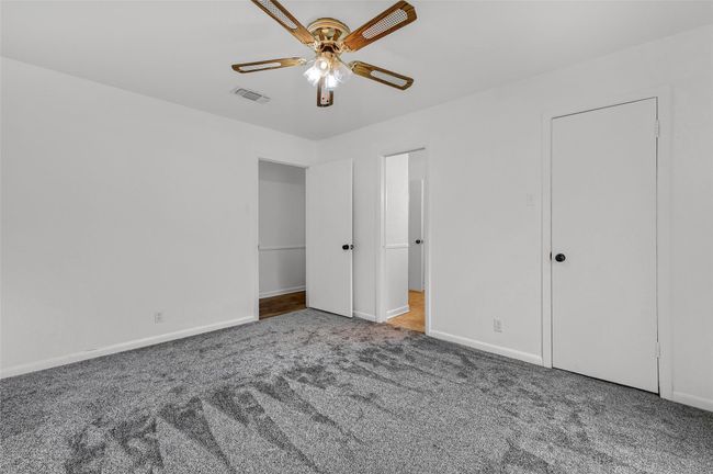 Unfurnished bedroom featuring carpet floors, baseboards, and a ceiling fan | Image 23