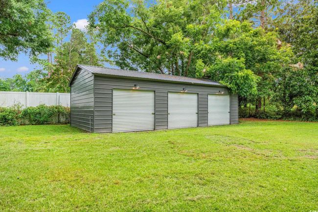 Detached garage with view of scattered trees | Image 36