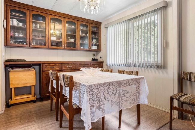 Dining room with a notable chandelier and wood finished floors | Image 10
