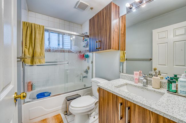 Bathroom featuring vanity, enclosed tub / shower combo, and tile patterned flooring | Image 22