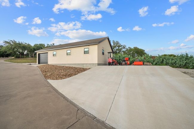 View of property exterior with stucco siding, driveway, and an attached garage | Image 33