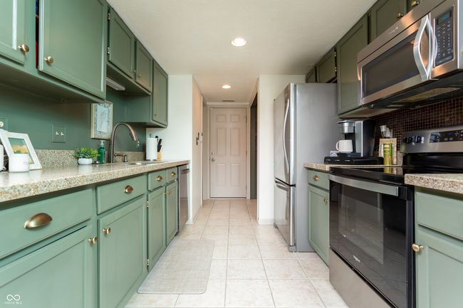kitchen with appliances with stainless steel finishes, green cabinetry, light countertops, and recessed lighting | Image 13