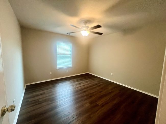 Unfurnished room with dark wood-style flooring, baseboards, and ceiling fan | Image 14