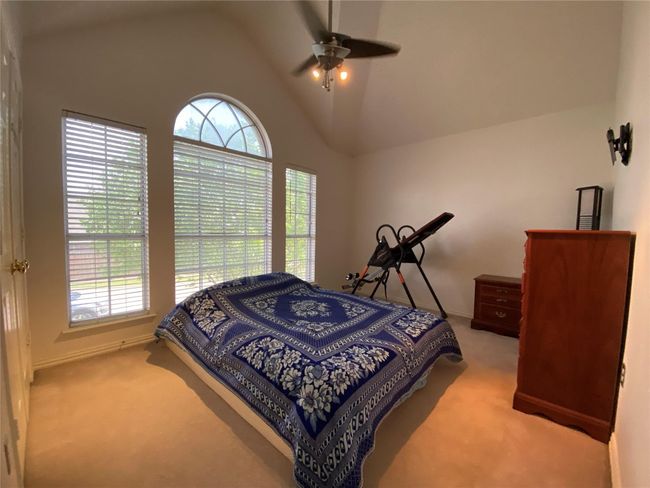 Bedroom with ceiling fan, light colored carpet, and lofted ceiling | Image 31