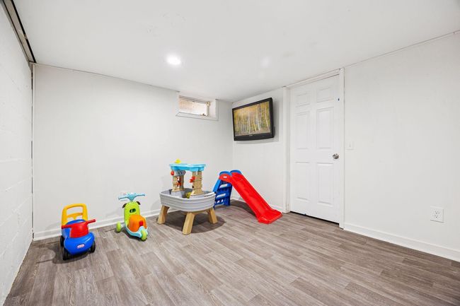 The lower-level bedroom features sleek LVP flooring, moderate closet and recessed lighting. | Image 15