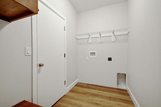 Laundry area with hookup for an electric dryer, hookup for a washing machine, and light wood-style floors | Image 13
