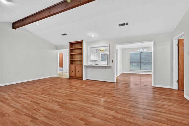 Unfurnished living room featuring a chandelier and light wood finished floors | Image 4