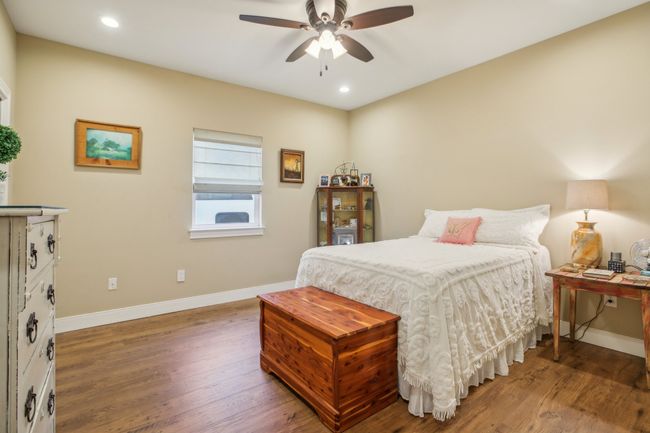 Bedroom with dark wood-type flooring and ceiling fan | Image 19