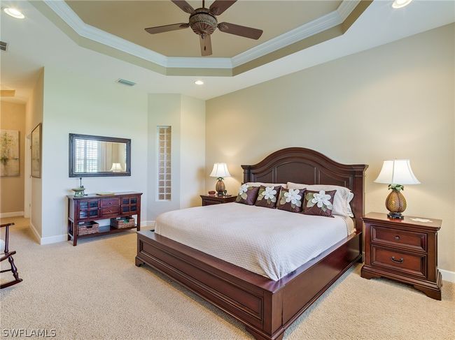Carpeted bedroom featuring ceiling fan, a tray ceiling, and crown molding | Image 15