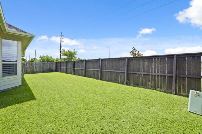 This private backyard space holds potential for outdoor entertaining, a serene garden, or a vibrant play area. A full house Generac generator (not shown) is also tucked away in this spacious backyard. | Image 25