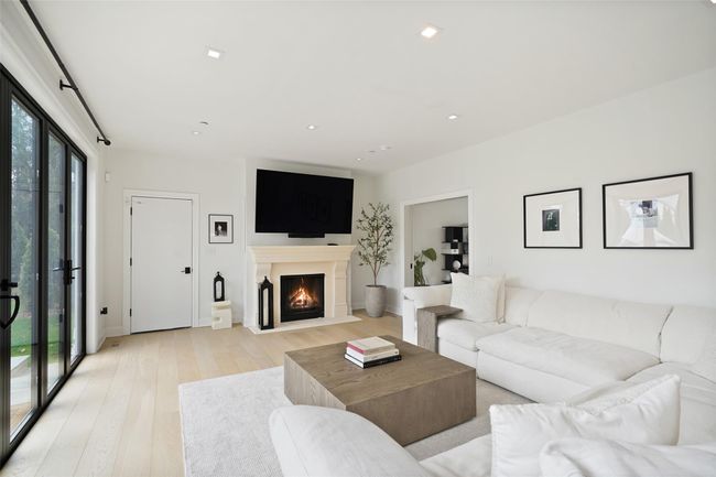 Living room featuring a fireplace with flush hearth, light wood-style flooring, baseboards, and recessed lighting | Image 11