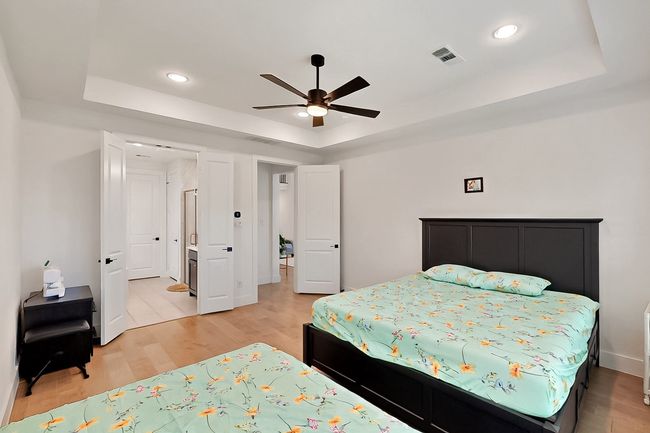 Bedroom with a raised ceiling, light wood-style floors, recessed lighting, and ceiling fan | Image 17