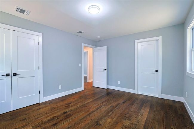 Unfurnished bedroom with dark wood-type flooring | Image 12