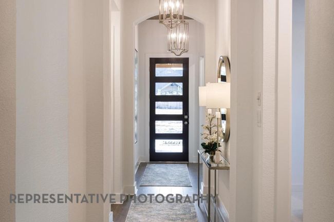 Entryway with a chandelier, plenty of natural light, wood finished floors, and arched walkways | Image 30