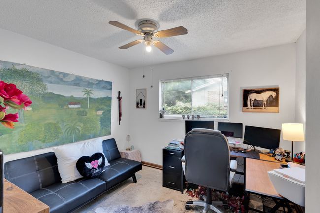Carpeted home office featuring a ceiling fan and a textured ceiling | Image 20