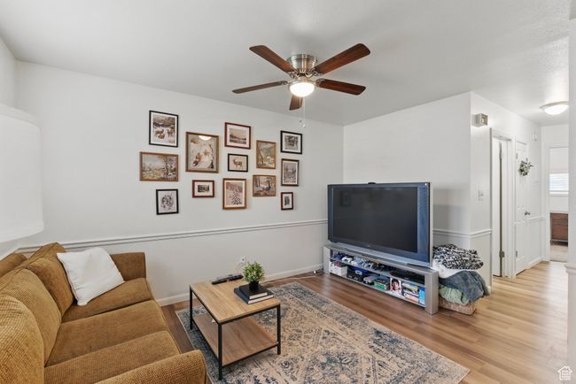 Living area featuring baseboards, a ceiling fan, and wood finished floors | Image 5