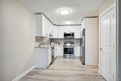 Kitchen view from living room shows pantry and counter-depth refrigerator | Image 3