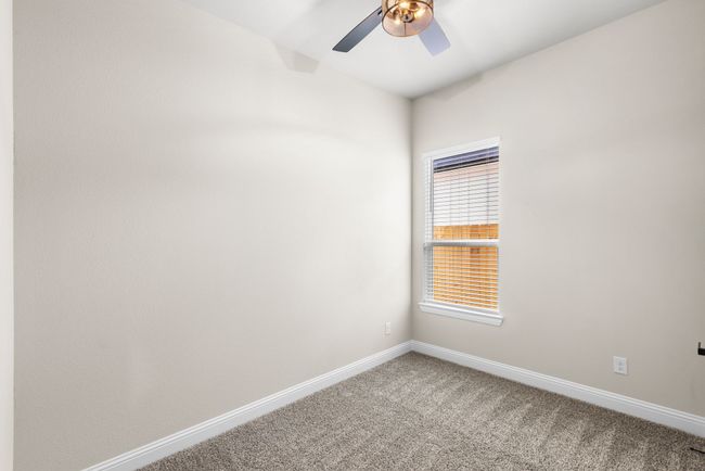 Secondary bedroom featuring baseboards, light colored carpet, and a ceiling fan | Image 21
