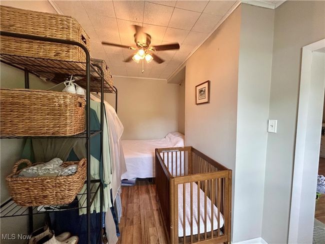 Bedroom with wood finished floors, crown molding, and ceiling fan | Image 12