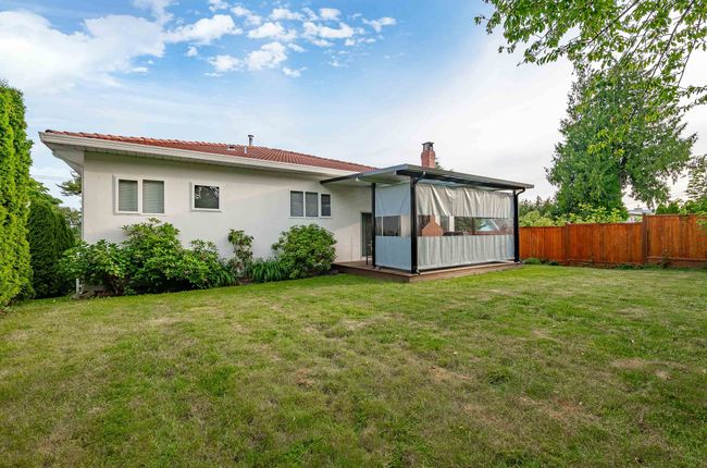 Back of house with a chimney, a sunroom, a tile roof, and stucco siding | Image 21