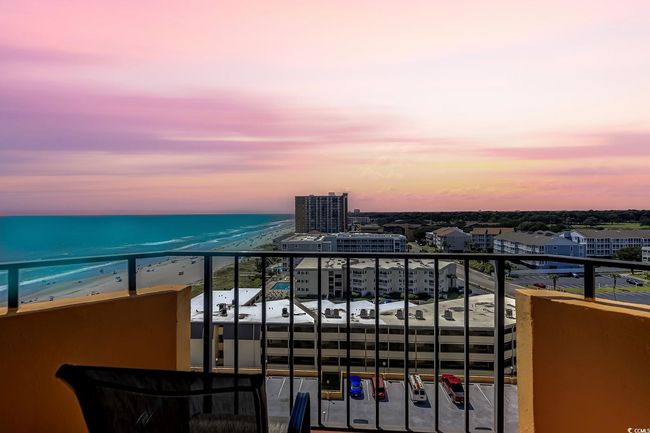 Balcony at dusk featuring a view of the beach and a water view | Image 40