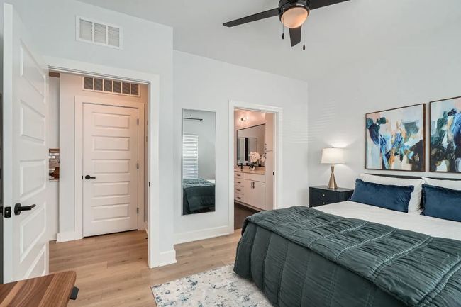 Master Bedroom featuring light wood finished floors, ensuite bath, and a ceiling fan | Image 11