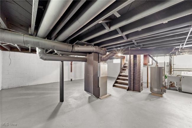 Unfinished basement with washer / clothes dryer, a sink, gas water heater, heating unit, and stairs | Image 28