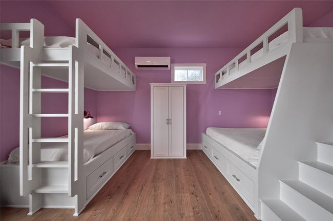 Bedroom with a wall mounted air conditioner and wood finished floors | Image 17