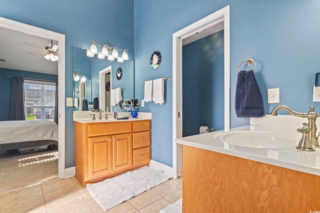 Ensuite bathroom with two vanities, ceiling fan, and tile patterned floors | Image 22