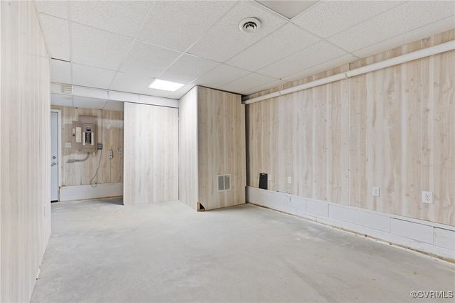 Basement with a paneled ceiling and electric panel | Image 28