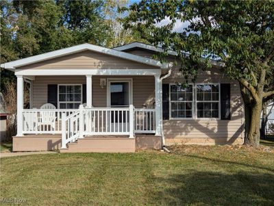 Bungalow with a front lawn and covered porch | Image 1