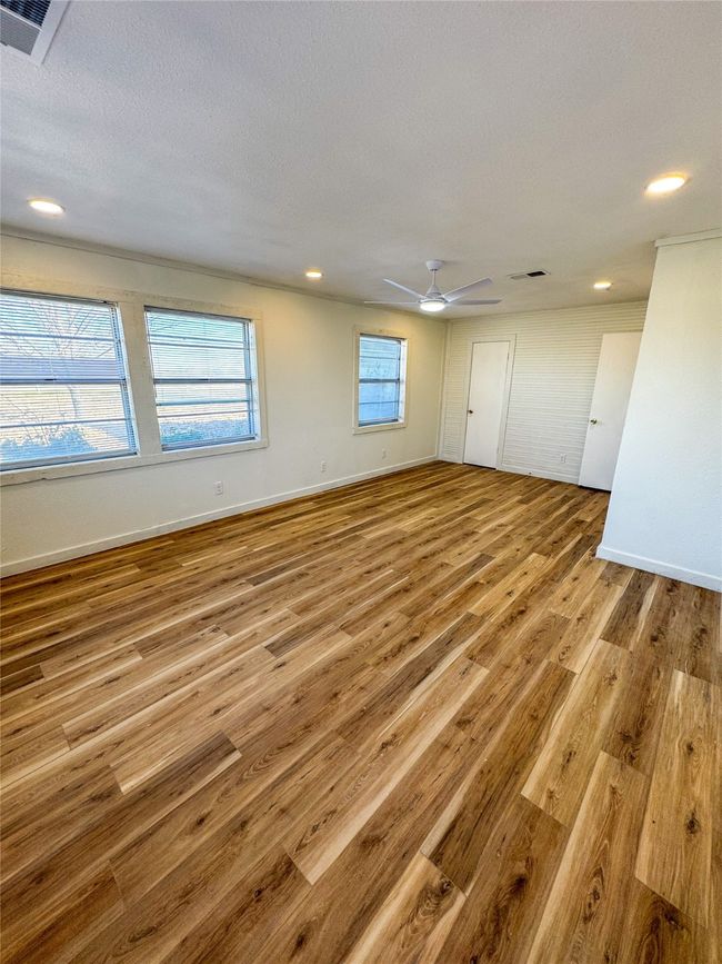 Unfurnished room featuring ceiling fan, visible vents, baseboards, and wood finished floors | Image 18