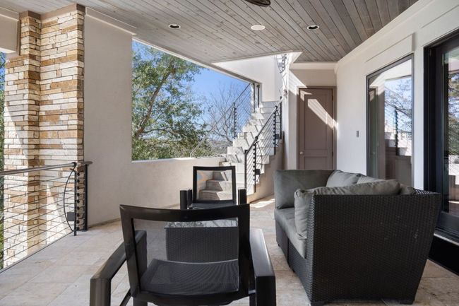Covered second floor terrace with stairway to third floor terrace. | Image 28