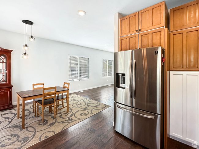 Kitchen with decorative light fixtures, stainless steel fridge with ice dispenser, and dark hardwood / wood-style flooring | Image 7