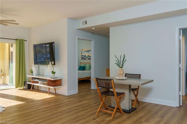 Dining room featuring a ceiling fan, wood finished floors, visible vents, and baseboards | Image 5