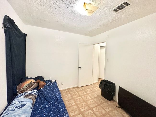 Bedroom with a textured ceiling and light flooring | Image 17