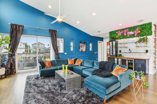 Living area featuring high vaulted ceiling, wine cooler, wood finished floors, recessed lighting, and a bar | Image 7
